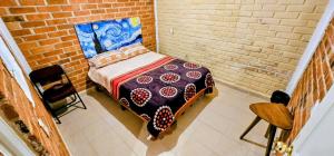 ein Schlafzimmer mit einem Bett in einer Ziegelwand in der Unterkunft El Corazón de Villa in Villa del Carbón