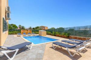una piscina con sedie a sdraio e una piscina di Villa Datil by Villa Plus a Es Mercadal