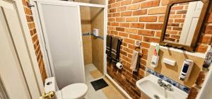 ein Badezimmer mit Toilette und Waschbecken und einer Ziegelwand in der Unterkunft El Corazón de Villa in Villa del Carbón + 24 Fotos