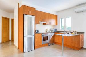 アス・マルカダルにあるVilla Datil by Villa Plusのキッチン(木製キャビネット、ステンレス製の冷蔵庫付)