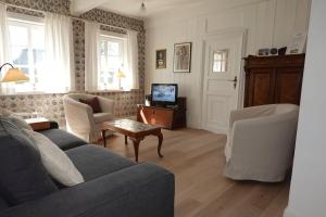 a living room with a couch and a tv at Welkimen tüs 1-Tradition in Oldsum