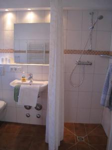 a white bathroom with a sink and a shower at Welkimen tüs 1-Tradition in Oldsum +7 photos