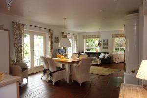 a kitchen and living room with a table and chairs at Ferienwohnung Klantem EG in Oldsum