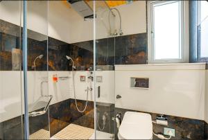 een badkamer met een glazen douche met toilet bij Moustache Select Mcleodganj in Dharamshala