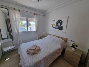 a small bedroom with a bed and a chair at Beautiful views lake golf house in Roldán +23 photos