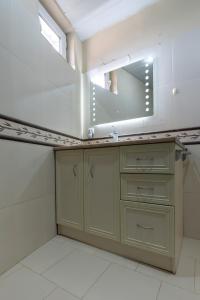 une salle de bain avec un lavabo et un miroir dans l'établissement Vake Charm Residence, à Tbilissi 25 autres photos
