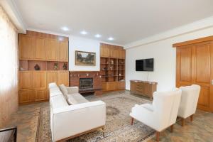 Elle comprend un salon doté d'un mobilier blanc et d'une cheminée. dans l'établissement Vake Charm Residence, à Tbilissi