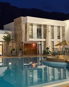 a large swimming pool in front of a building at Paradise Villas in Birgulyuk
