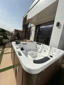a large white bath tub sitting on top of a balcony at Paradise Villas in Birgulyuk