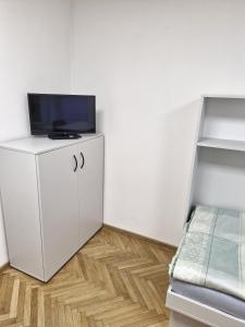 a room with a white cabinet with a tv on top at ŠD Němcovej 1 in Košice