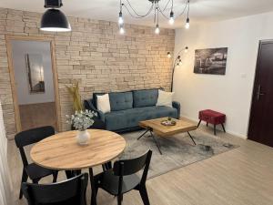 a living room with a blue couch and a table at Four Seasons in Rijeka