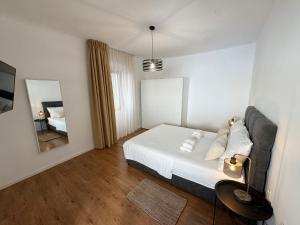 a bedroom with a bed and a couch and a mirror at Four Seasons in Rijeka
