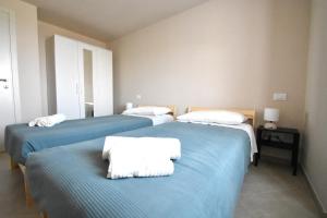 a bedroom with two beds with blue sheets and white pillows at Villa Il Circolo Bassone in Pontremoli