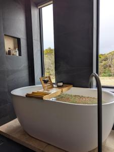 a white bath tub in a bathroom with a window at The Dunes in Island Beach