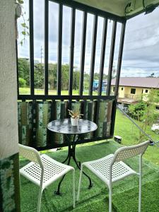 SalabanにあるVista Suite with Balconyのパティオ(テーブル、椅子2脚、窓付)