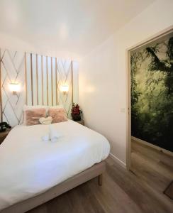a bedroom with a white bed with two stuffed animals on it at Love N Nature in Serris