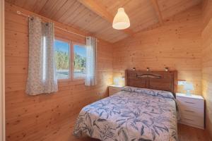 a bedroom with a bed in a wooden cabin at Bungalow Luna in Chiclana de la Frontera +35 photos