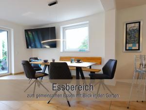 a dining room with a table and chairs at Ferienhaus Höckelheim - FeWo Blaue Lagune - neu, modern & geräumig - 100 qm - 3 Schlafzimmer - bis 6 Gäste, Babies reisen gratis - Garten, Grill & Terrasse - Fußbodenheizung - Smart-TV - Küche mit Backofen, Spülmaschine & Toaster - nahe Göttingen in Northeim