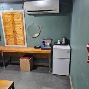 a kitchen with a table and a refrigerator and a mirror at Guri C Boutique Hotel in Guri +28 photos