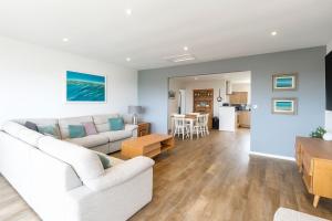 Una sala de estar con un sofá blanco y una mesa. en Wheal Francis - Hot Tub - Accessible Bungalow - Free Wi-Fi - Parking, en Helston