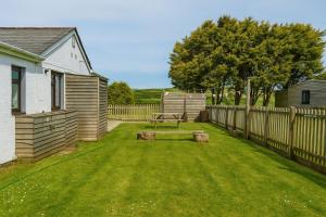un patio con una valla de madera y un banco en Wheal Francis - Hot Tub - Accessible Bungalow - Free Wi-Fi - Parking, en Helston