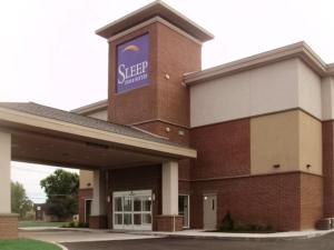 a building with a sign on the side of it at Sleep Inn & Suites East Syracuse in East Syracuse
