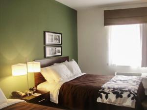 a hotel room with a bed and a window at Sleep Inn & Suites East Syracuse in East Syracuse