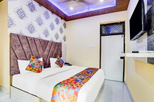 a bedroom with a bed and a television in it at FabHotel Ratraksh in Kānpur