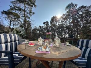 a wooden table with cups and plates on a patio at Haus am Meer in Thiessow