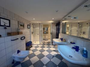 a bathroom with three sinks and two toilets at Haus am Meer in Thiessow +28 photos