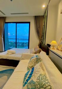 una camera d'albergo con due letti e una grande finestra di Nghỉ dưỡng Vinhomes Grand Park Quận 9 a Kon Rung (1)