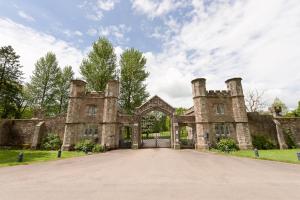 an old stone house with a gate in front at South Lodge at Pudleston Court in Hatfield