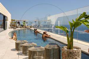 a group of people in a swimming pool on a building at 24th Floor Luxury Sea View Apart-Hotel Pools Spa Gym & Rooftop I Mercury Tower in St. Julianʼs