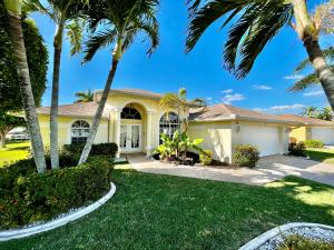 a house with palm trees in front of it at Villa Malibu in Cape Coral Hospital Heliport