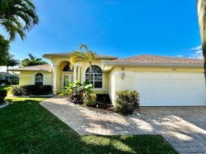 a house with a palm tree in front of it at Villa Malibu in Cape Coral Hospital Heliport