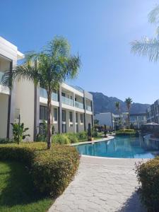a building with a swimming pool in front of a building at Fabulous Studio at stunning Palmera Resort on Medditerranean coast in Karavas