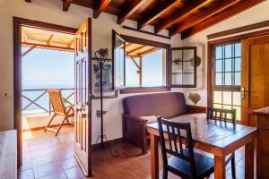a dining room with a table and a view of the ocean at CASAS EN FINCA ECOLÓGICA LA ESPIRAL, NATURALEZA, CALMA Y VISTAS al MAR, in Icod el Alto