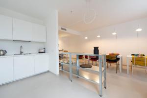 a kitchen with white cabinets and a table with chairs at In Piazza BnB in San Salvo