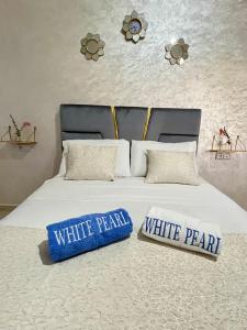 a white bed with two pillows on top of it at Chauen White Pearl Apartments in Chefchaouene