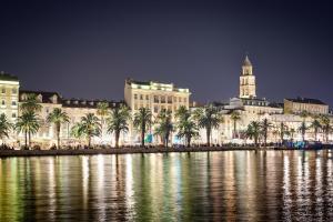 a view of a city with palm trees and a building at Beautiful Apartment Jukic in Podstrana