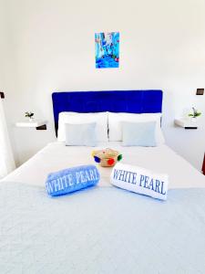 two pillows on a bed with a blue head board at Chauen White Pearl Apartments in Chefchaouene +25 photos