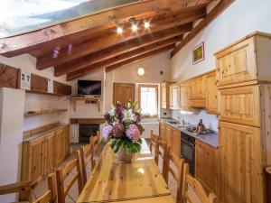 a kitchen with a wooden table with a vase of flowers at Apartment with Fireplace in Antey-Saint-André