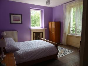 a purple bedroom with a bed and a fireplace at Chateau Le Vieil Etang in Saint-Sauveur-le-Vicomte