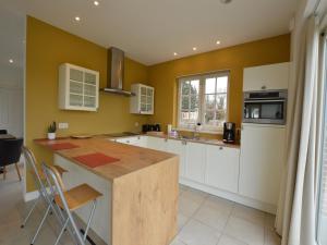 eine Küche mit gelben Wänden und einer hölzernen Arbeitsplatte in der Unterkunft Sint-Amands Country Escape in Sint-Amands