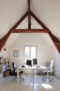 un ufficio in soffitta con una scrivania bianca con due computer di Maison avec jardin, à deux pas du centre-ville a Clermont-Ferrand