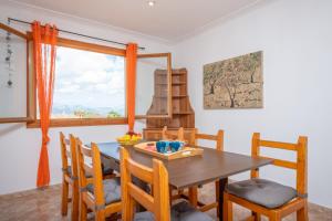 a dining room with a table and chairs and a window at Can Kalet in Costitx