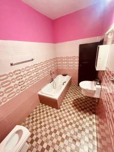 a bathroom with a toilet and a tub and a sink at Harmonic Hideout in Varkala