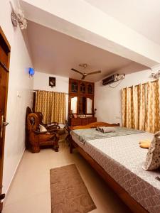 a bedroom with a bed and a chair at Harmonic Hideout in Varkala