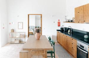 a kitchen with a wooden table with a vase on it at Casa Majú - Algarve in Valados