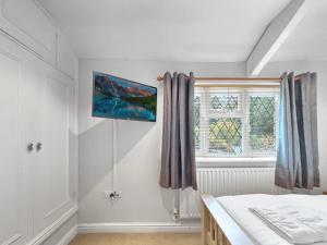 a bedroom with a bed and a window at Amaya Eleven - 3 bed cottage in village in Harlaxton